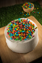 Colorful Chocolate candies on white cream cake, copy space, selective focus
