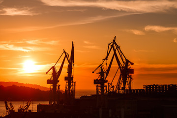 Obraz premium construction cranes silhouettes