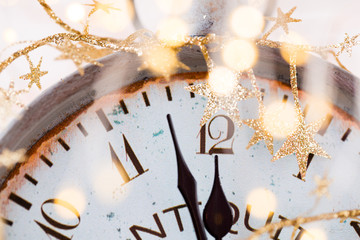 Obraz na płótnie Canvas vintage alarm clock is showing midnight. It is twelve o'clock, christmas and bokeh, holiday happy new year festive concept on light bokeh background