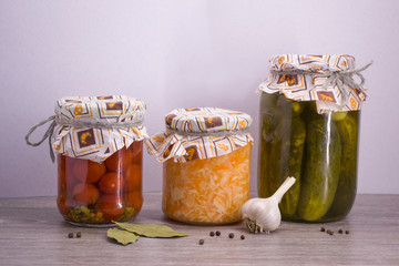 Salted tomatoes, Pickles and salted cabbage and garlic in glass jars.