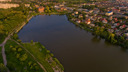 Fototapeta na wymiar Aerial view of the summer city park near the lake. Beautiful view of nature.