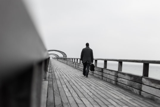 Mann mit Tasche auf Seebr&uuml;cke