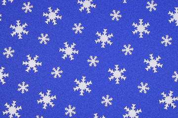 White snowflake confetti on blue background.