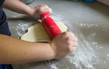 Flattening dough with a rolling pin