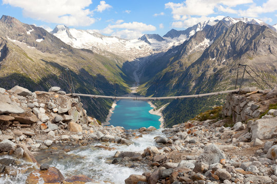 The tibetan bridge near Olperer refuge with Lake Schlegeispeicher on the background, Zillertal Alps, tyrol, Austria.