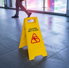 Yellow Caution wet floor sign on wet floor