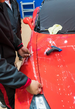 Worker Install Car Paint Protection Film With Spatula