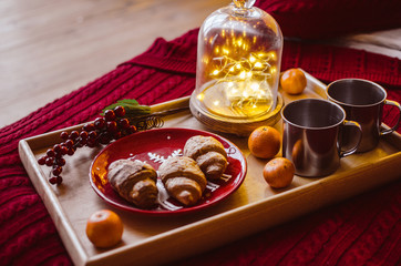 Christmas party, croissants with hot chocolate. Christmas tree with lights