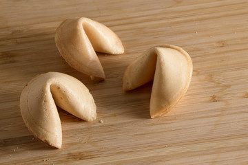 three chinese fortune cookies on a wooden background with copy space