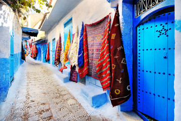 Moroccan handmade crafts, carpets and bags hanging in the narrow street of Essaouira in Morocco...