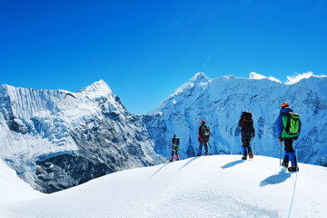 Hikers with backpacks reaches the summit of mountain peak. Success freedom and happiness...