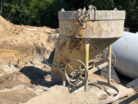 closeup of old yellow concrete pouring device on the background of soil. iron concrete mixer at a construction site. machinery at construction site