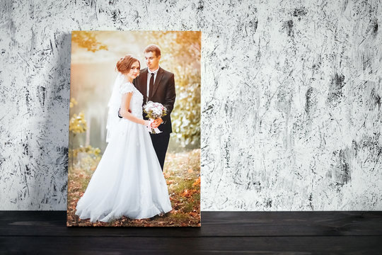 Photo of a wedding couple printed on canvas. Photography with stretch on a wooden frame on a white wall background with copy space