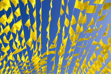 garlands of yellow holiday flags against a blue sky