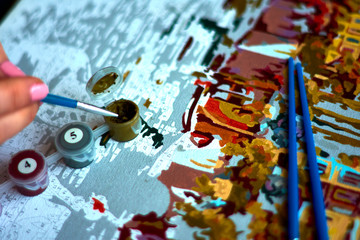 Fototapeta premium the girl draws a brush paints a picture of the numbers