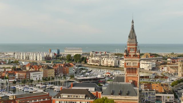 View of the city of Dunkirk, in the north of France. The town hall belfry in the foreground and the port, next to the north sea, in the background. Filmed in October.