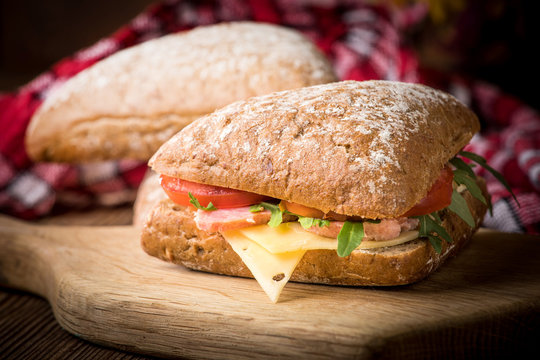 Triangular sandwich with cheese, ham and tomato.