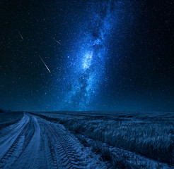 Stunning milky way over field with country road at night