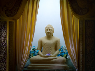 Ancient statue of sitting in meditation Buddha in the temple of Sri Lanka.