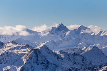 Fototapeta na wymiar High peaks mountains in winter with clouds in Austrian Alps