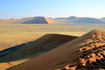 Fototapeta na wymiar Blick von einer großen Düne in Namibia in Afrika bei blauem Himmel