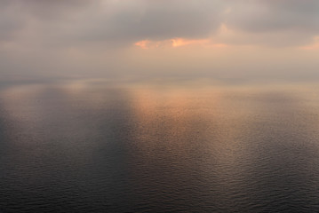 Dramatic sea at sunset in cloudy weather with beautiful reflection. blur and smooth reflection