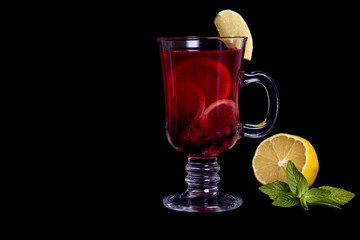 tea with currant berries, lemon and mint on a black background