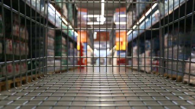 Empty trolley moving through supermarket aisle
