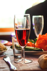 A glass of red wine is on the table.