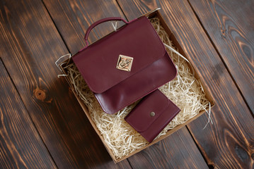 Gift box with a leather bag and purse on a dark wooden background. It can be used as a background