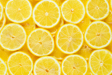 A slices of fresh juicy yellow lemons.  Texture background, pattern.