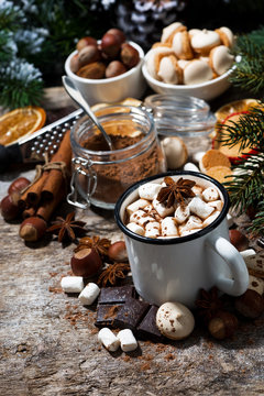 mug of hot chocolate with marshmallows and sweets on wooden table, vertical top view