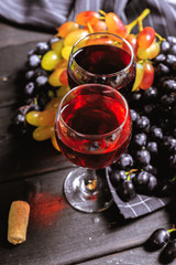 wine with branches of white grapes. On a wooden table.