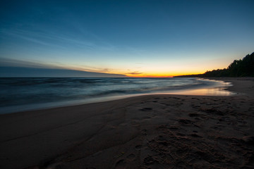 long exposure sea beach with rocks and washed out waves of water