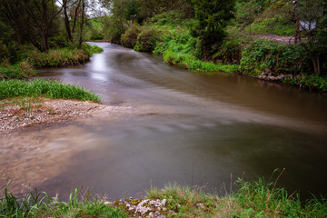 long exposure rocky mountain river in summer with high water stream level