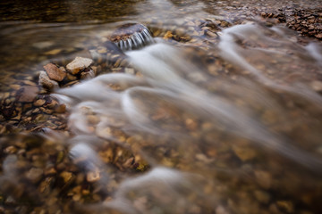 long exposure rocky mountain river in summer with high water stream level