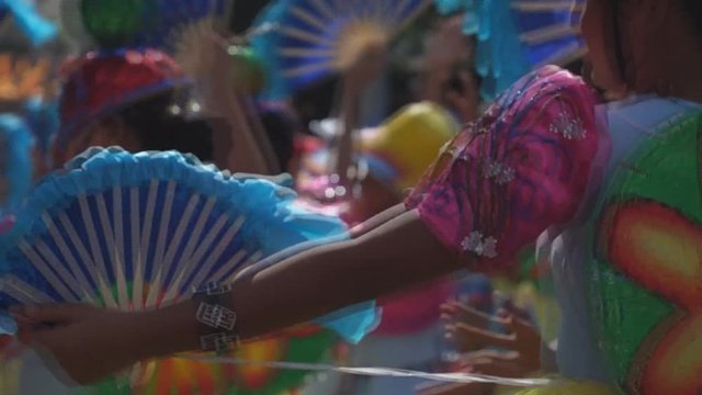 group of carnival folk and cultural dancers in colorful handcrafted coconut costume dance along the streets to honor a patron saint. Public Event