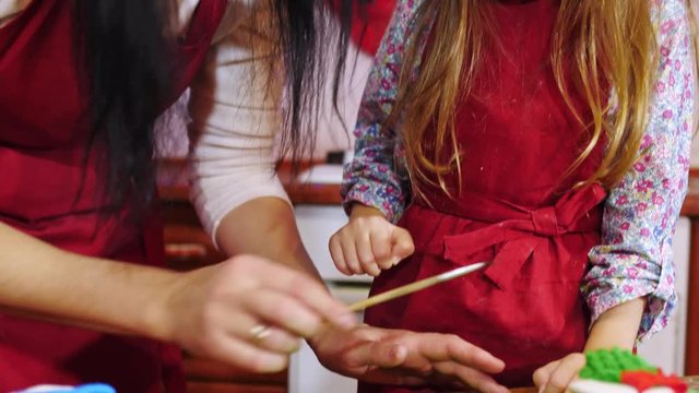 Close-up of mother and daughter are decorating with sugar mastic a cupcake
