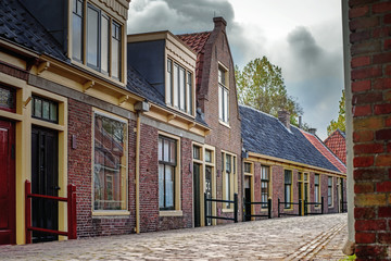 Obraz premium View on traditional Dutch houses and streets in a recreated heritage museum with beautiful historic vintage scenes from Holland.