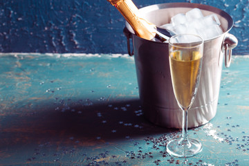 Champagne bottle in bucket with ice and glasses of champagne