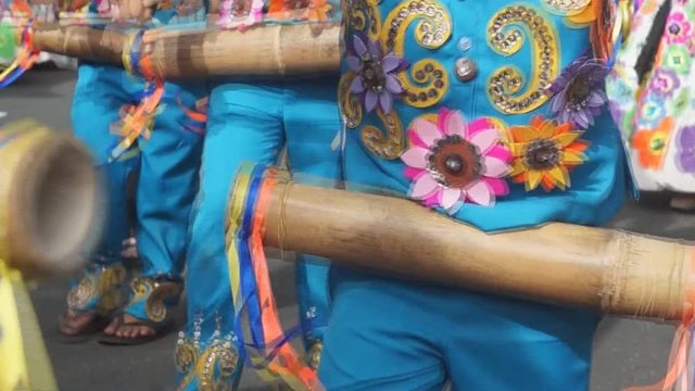group of carnival folk and cultural dancers in colorful handcrafted coconut costume dance along the streets to honor a patron saint. Public Event