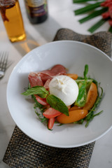 Mozzarella and ham salad with basil leaf