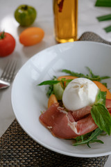 Mozzarella and ham salad with basil leaf