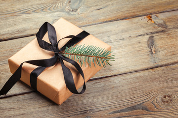 Christmas gift boxes and fir tree branch on wooden table.
