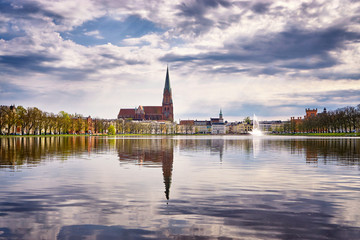 Clouds and old town of Schwerin are reflected in the lake Pfaffenteich.