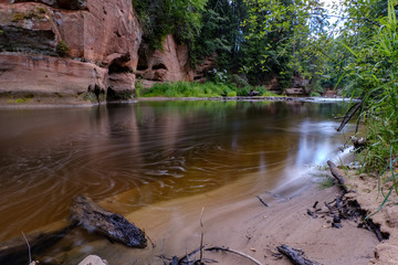 long exposure rocky mountain river in summer with high water stream level