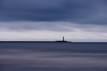 long exposure sea beach with rocks and washed out waves of water