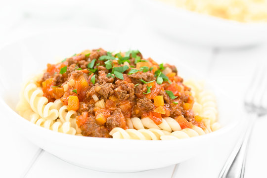 Homemade vegan bolognese sauce made with soy meat, fresh tomatoes, onion and garlic served on fusilli pasta and sprinkled with parsley (Selective Focus, Focus in the middle of the image)