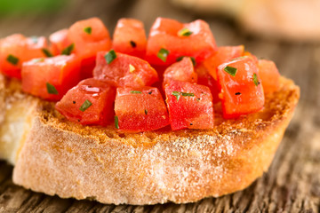 Fresh homemade tomato and basil bruschetta traditional Italian antipasto (Selective Focus, Focus on the first tomato pieces on the bread)
