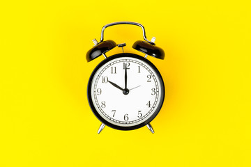 Alarm clock on bright yellow background  close up